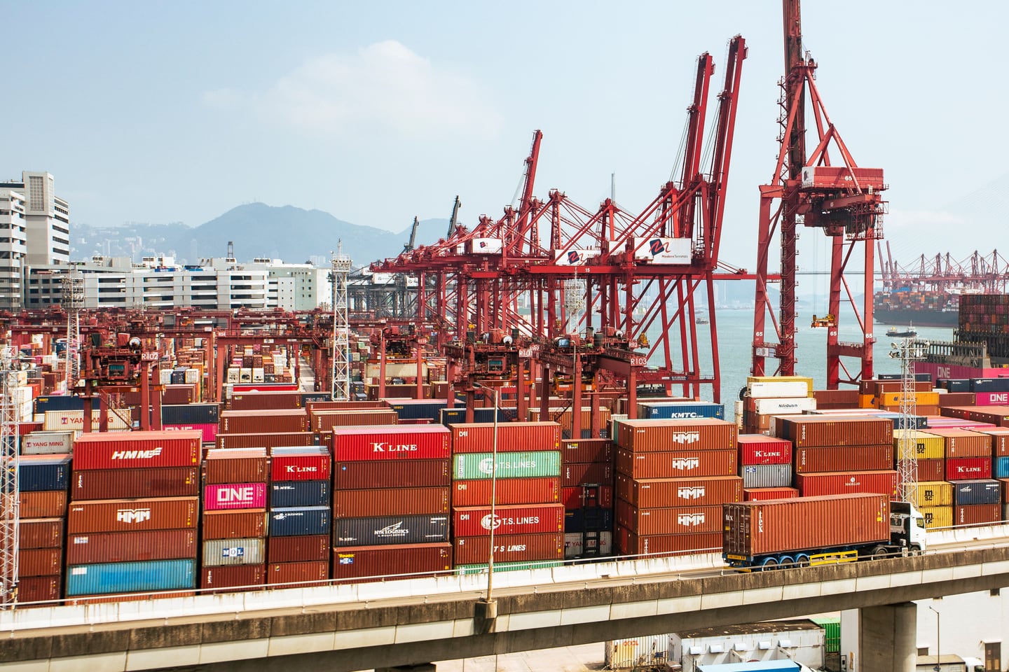 Cargo containers and cranes fill a working seaport.