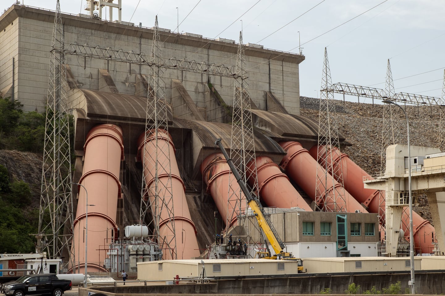 Hydroelectric power infrastructure crosses a broad river.